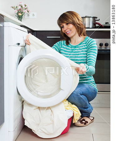 Happy girl using washing machine 13863180
