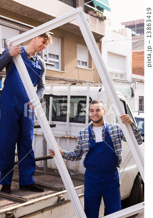 Two workers delivering PVC profiles Two workers delivering PVC profiles 13863419