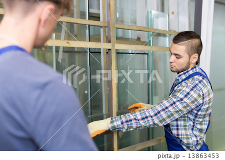 Two workmen working with glass 13863453
