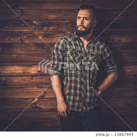 Handsome man wearing checkered  shirt in wooden rural house interior 13867945
