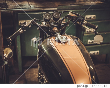 Vintage style cafe-racer motorcycle in customs garage Vintage style cafe-racer motorcycle in customs garage 13868018