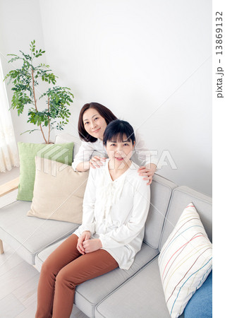 ソファに並ぶミドルの女性 ソファに並ぶミドルの女性 13869132