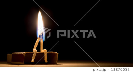 two matches burning sitting together on the matchbox in the dark two matches burning sitting together on the matchbox in the dark 13870052