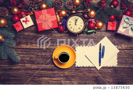 Hot coffee with letter near christmas gifts on wooden table. 13875630