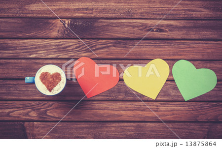 Cup with coffee and heart shape papers on wooden table. Cup with coffee and heart shape papers on wooden table. 13875864