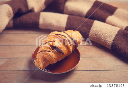 french croissant and scarf on a wooden table 13876193