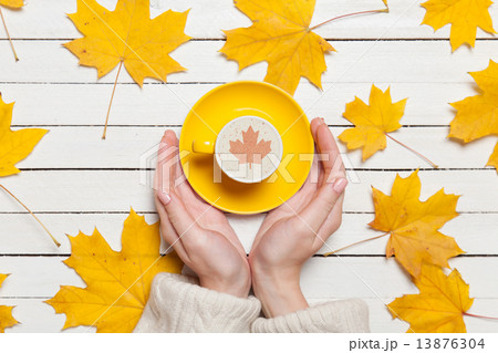 Female hands holding cup of coffee on wooden table. 13876304