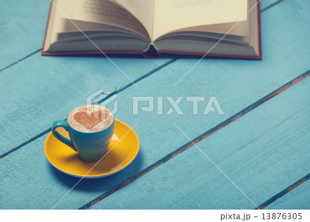 Cup of coffee with book on blue wooden table. Cup of coffee with book on blue wooden table. 13876305