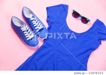 Gumshoes, sunglasses and dress on pink background. 13876325
