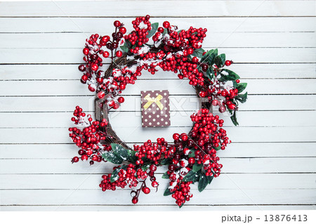 Holly christmas wreath with gift box on wooden table. Holly christmas wreath with gift box on wooden table. 13876413