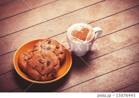 Cookie and cup of coffee on wooden table. 13876445