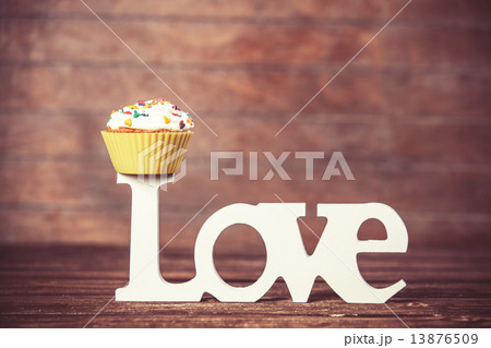 Cupcake and word Love on wooden table. Cupcake and word Love on wooden table. 13876509
