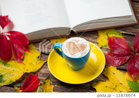 Autumn leafs, book and coffee cup on wooden table. Autumn leafs, book and coffee cup on wooden table. 13876674