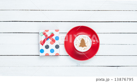 Gift box and cappuccino on white wooden table. Gift box and cappuccino on white wooden table. 13876795