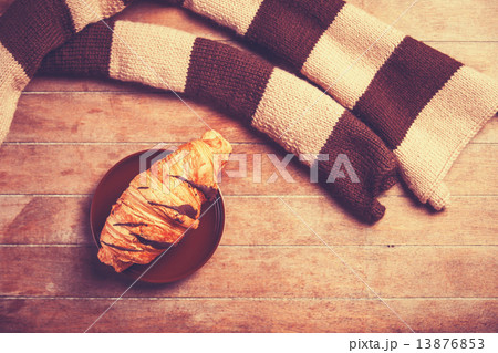 french croissant and scarf on a wooden table 13876853