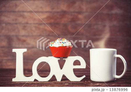 Cupcake, coffee and word Love on wooden table. Cupcake, coffee and word Love on wooden table. 13876996