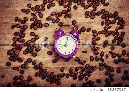 alarm clock and coffee beans on a wooden table. 13877357