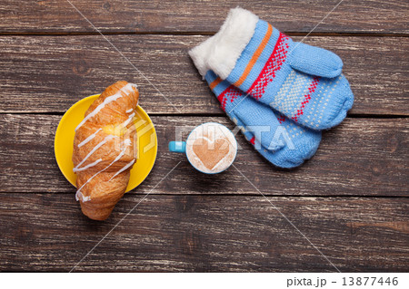 Gloves and cup of coffee on wooden table. Gloves and cup of coffee on wooden table. 13877446