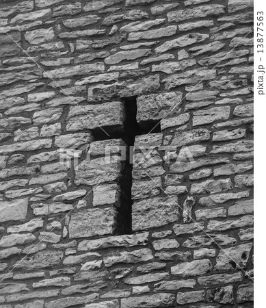 A cross shaped hole in an old brick wall 13877563
