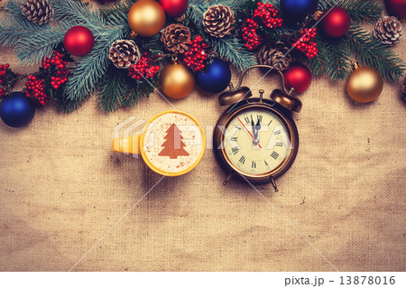 Hot cappuccino with christmas tree shape and alarm clock on a ta Hot cappuccino with christmas tree shape and alarm clock on a ta 13878016