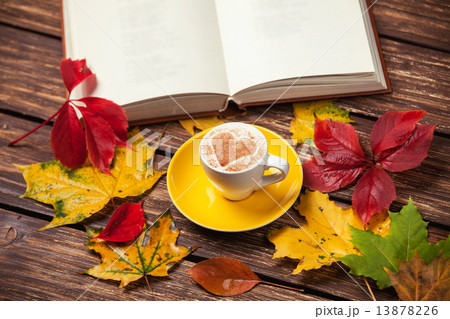 Autumn leafs, book and coffee cup on wooden table. Autumn leafs, book and coffee cup on wooden table. 13878226