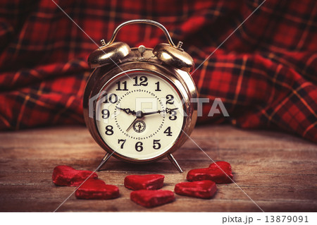 Retro alarm clock with cookie on a table 13879091