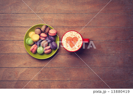 Cup and macarons on wooden background Cup and macarons on wooden background 13880419