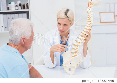 Doctor explaning spine model to senior patient Doctor explaning spine model to senior patient 13881446