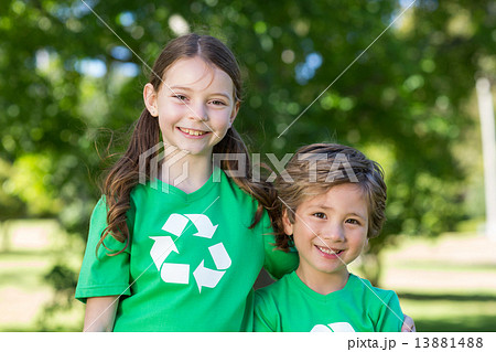 Happy siblings in green smiling at the camera Happy siblings in green smiling at the camera 13881488