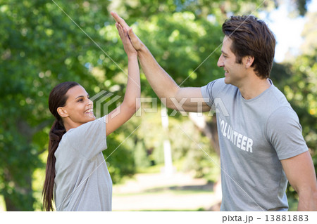 Happy volunteer couple high fiving Happy volunteer couple high fiving 13881883