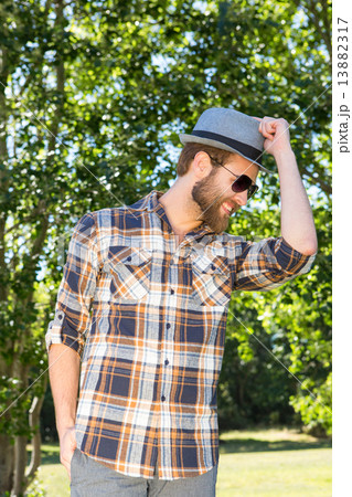 Handsome hipster smiling in the park 13882317