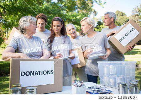 Happy volunteer family holding donation boxes Happy volunteer family holding donation boxes 13883007
