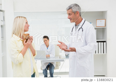 Veterinarian explaining things at cat owner Veterinarian explaining things at cat owner 13883021