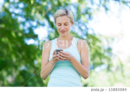 Pretty blonde using smartphone 13883084