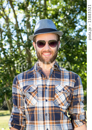 Handsome hipster smiling in the park Handsome hipster smiling in the park 13883321