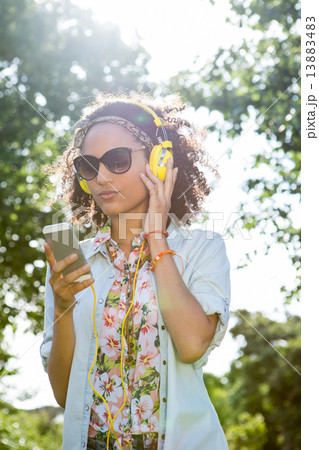 Pretty hipster using her smartphone Pretty hipster using her smartphone 13883483
