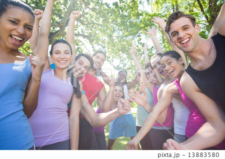 Fitness group cheering at camera in park Fitness group cheering at camera in park 13883580