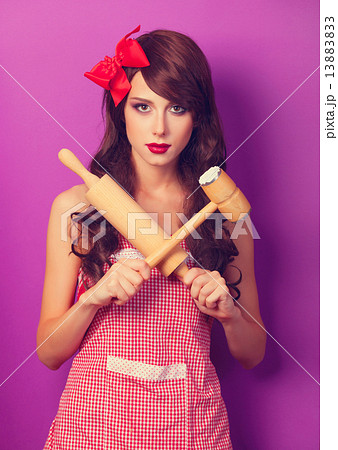 Beautiful brunette housewife with rolling pin on violet backgrou 13883833
