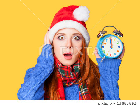 Redhead girl with alarm clock on yellow background. 13883892