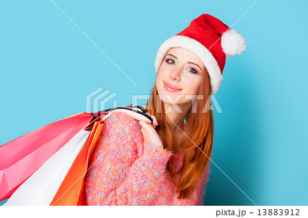 Redhead girl with shopping bags on blue background. 13883912