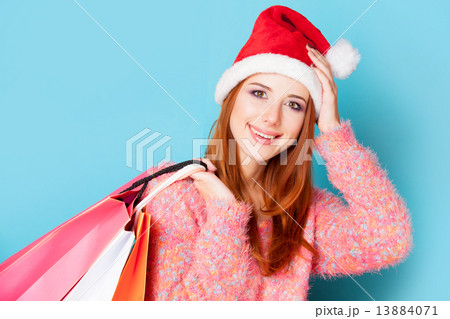Redhead girl with shopping bags on blue background. 13884071