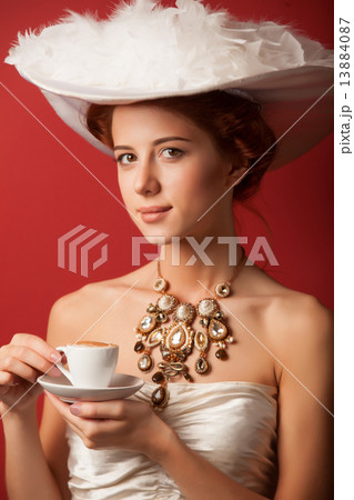 Portrait of redhead edvardian women with cup on red background. Portrait of redhead edvardian women with cup on red background. 13884087
