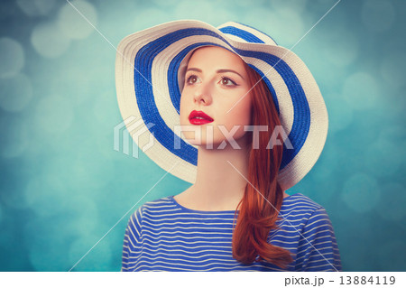 Redhead girl in hat on blue background. 13884119