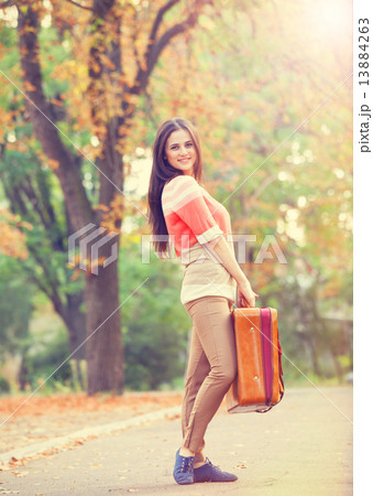 Beautiful brunette girl with suitcase in the park. Beautiful brunette girl with suitcase in the park. 13884263