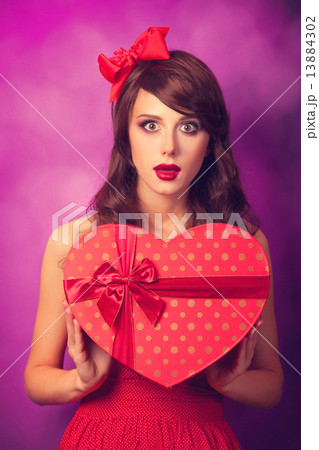 Beautiful brunette girl with heart shape gift on violet backgrou Beautiful brunette girl with heart shape gift on violet backgrou 13884302