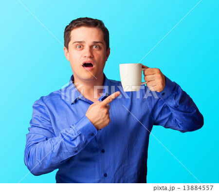 Surprised man in shirt with cup on blue background. Surprised man in shirt with cup on blue background. 13884557