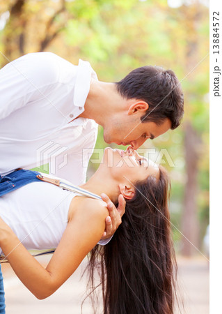 Teen couple kissing in the park in autumn time 13884572