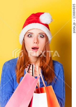 Redhead girl with shopping bags on yellow background. Redhead girl with shopping bags on yellow background. 13884605