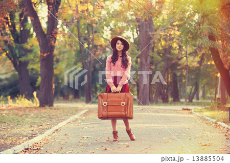 Beautiful brunette girl with suitcase in the park. 13885504