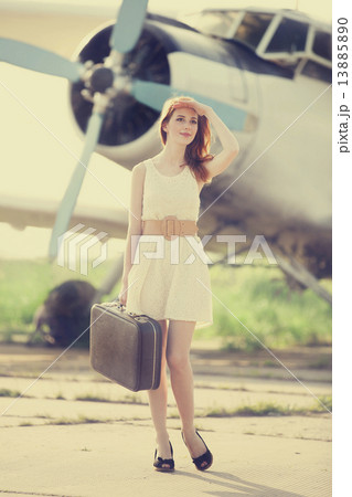 Lonely girl with suitcase at near airplane. Lonely girl with suitcase at near airplane. 13885890